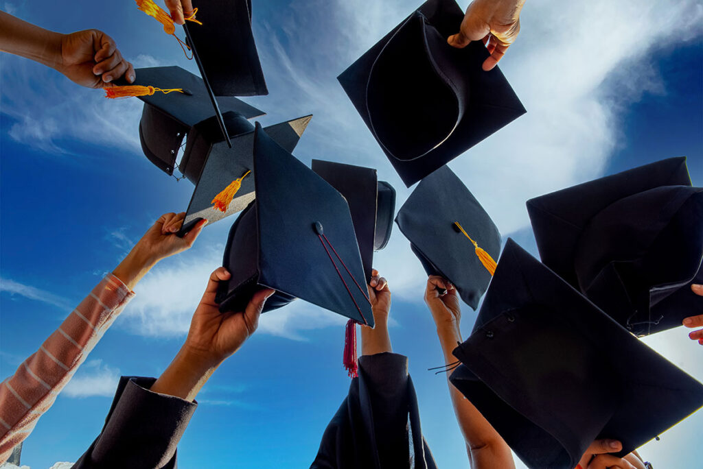 students holding graduation caps